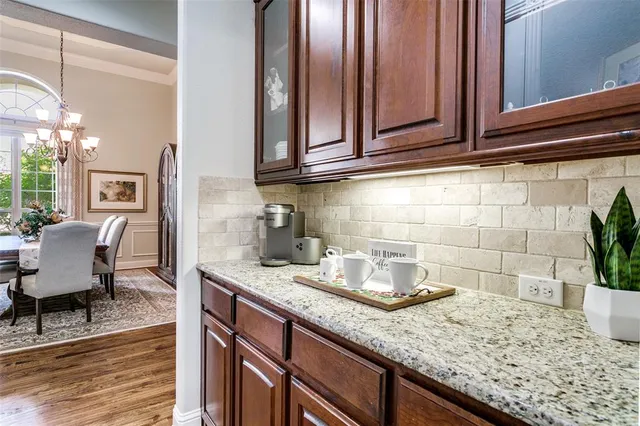 a kitchen with granite countertop a sink a stove and cabinets