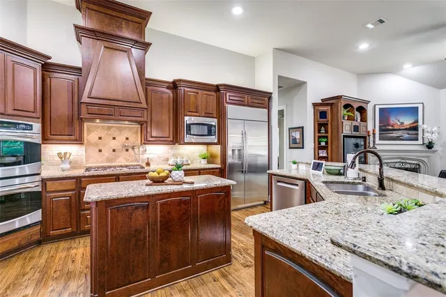 a kitchen with stainless steel appliances granite countertop a sink stove and refrigerator