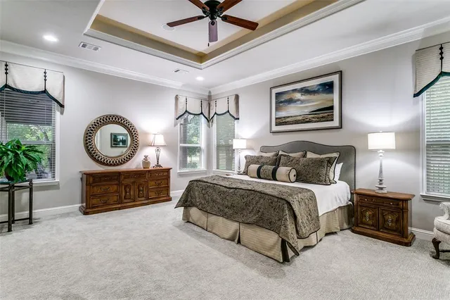a spacious bedroom with a bed a dresser and potted plant