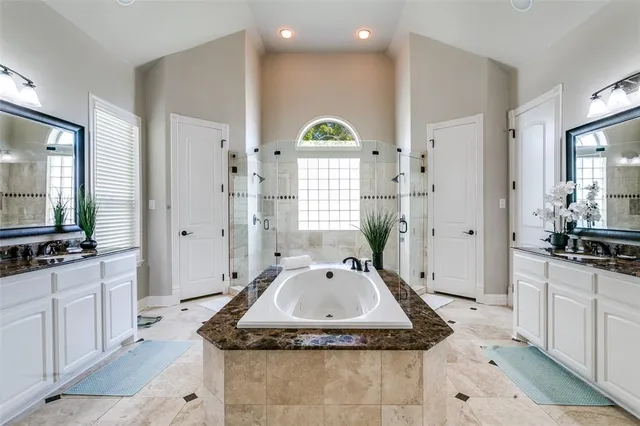 a bathroom with granite countertop a sink a mirror and a bathtub
