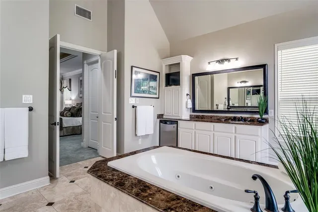 a large bathroom with a tub and a large mirror