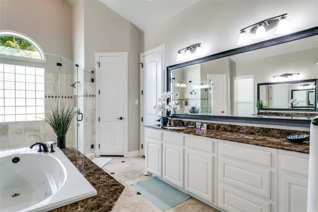 a bathroom with a tub a sink and a large mirror
