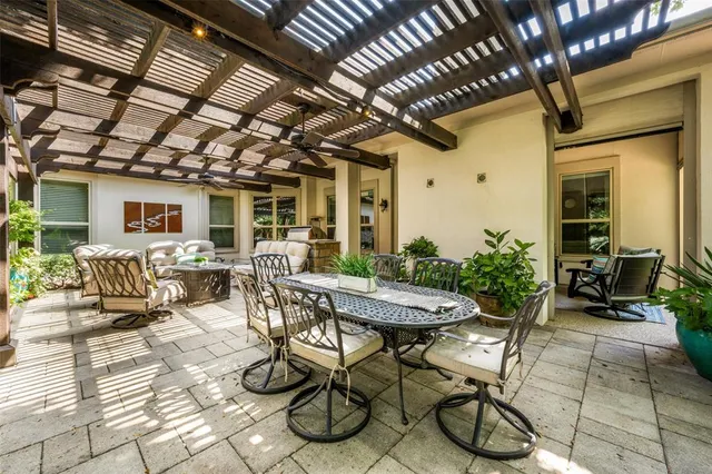 a view of a dinning table and chairs in patio of the house