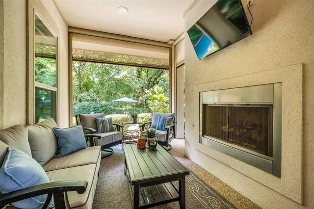 a living room with furniture a fireplace and a floor to ceiling window
