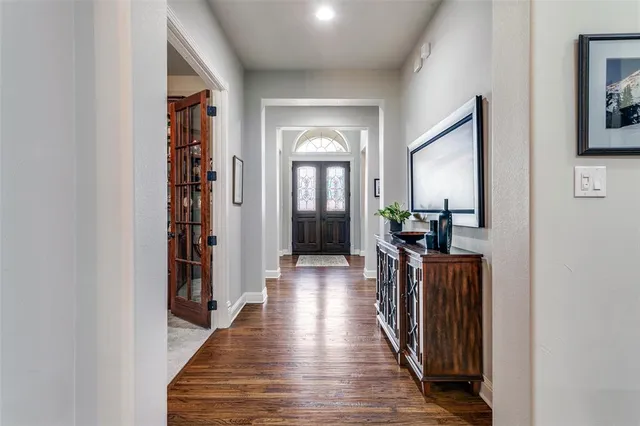 a view of a hallway with wooden floor and a living room