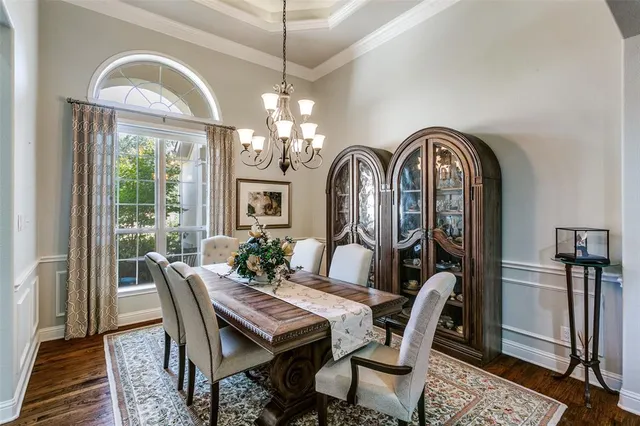 a view of a dining room with furniture a chandelier and wooden floor