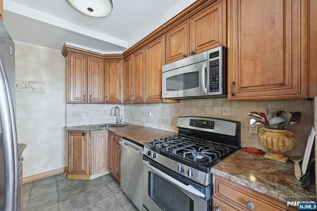 2 Horizon Road, Unit 1010 Fort Lee, NJ 07024 - Photo 11 of 42 a kitchen with stainless steel appliances granite countertop a stove and a microwave
