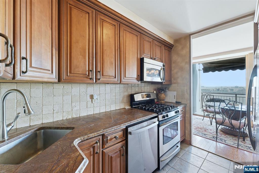 2 Horizon Road, Unit 1010 Fort Lee, NJ 07024 - Photo 12 of 42 a kitchen with stainless steel appliances granite countertop a sink stove and cabinets