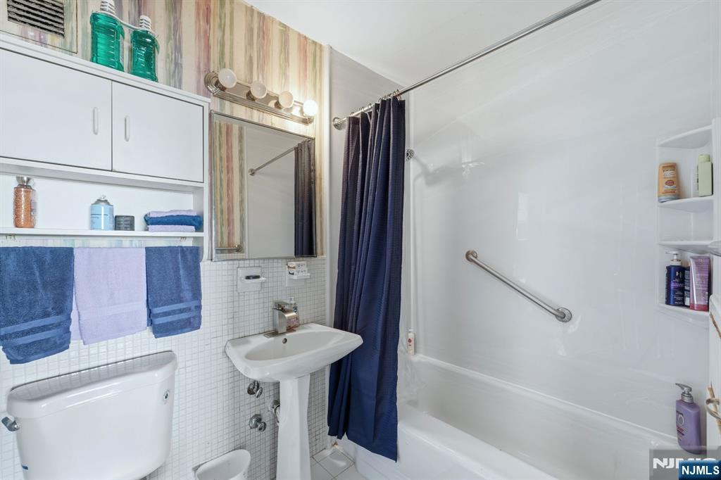 2 Horizon Road, Unit 1010 Fort Lee, NJ 07024 - Photo 13 of 42 a bathroom with a sink a toilet and shower