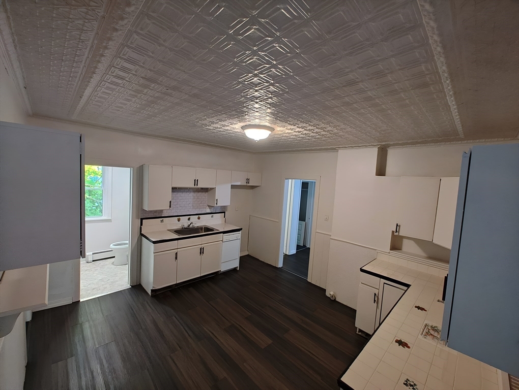 74 Linden Street, Unit 2 Holyoke, MA 01040 - Photo 4 of 20 a kitchen with granite countertop white cabinets and wooden floor