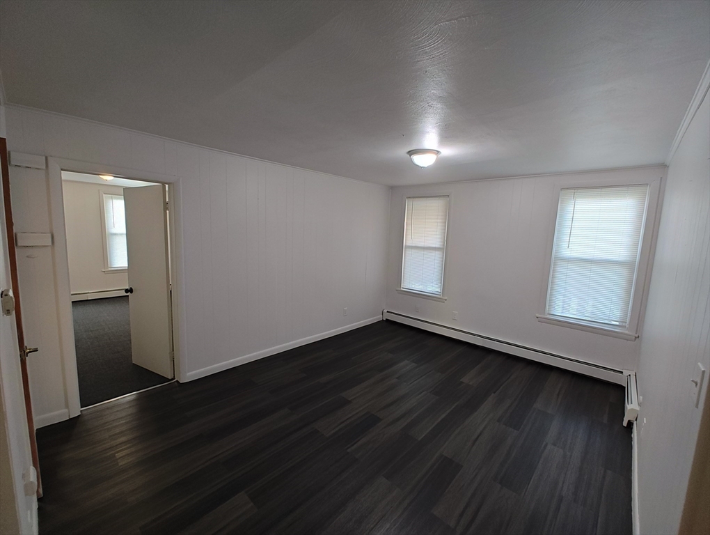 74 Linden Street, Unit 2 Holyoke, MA 01040 - Photo 9 of 20 an empty room with wooden floor and windows