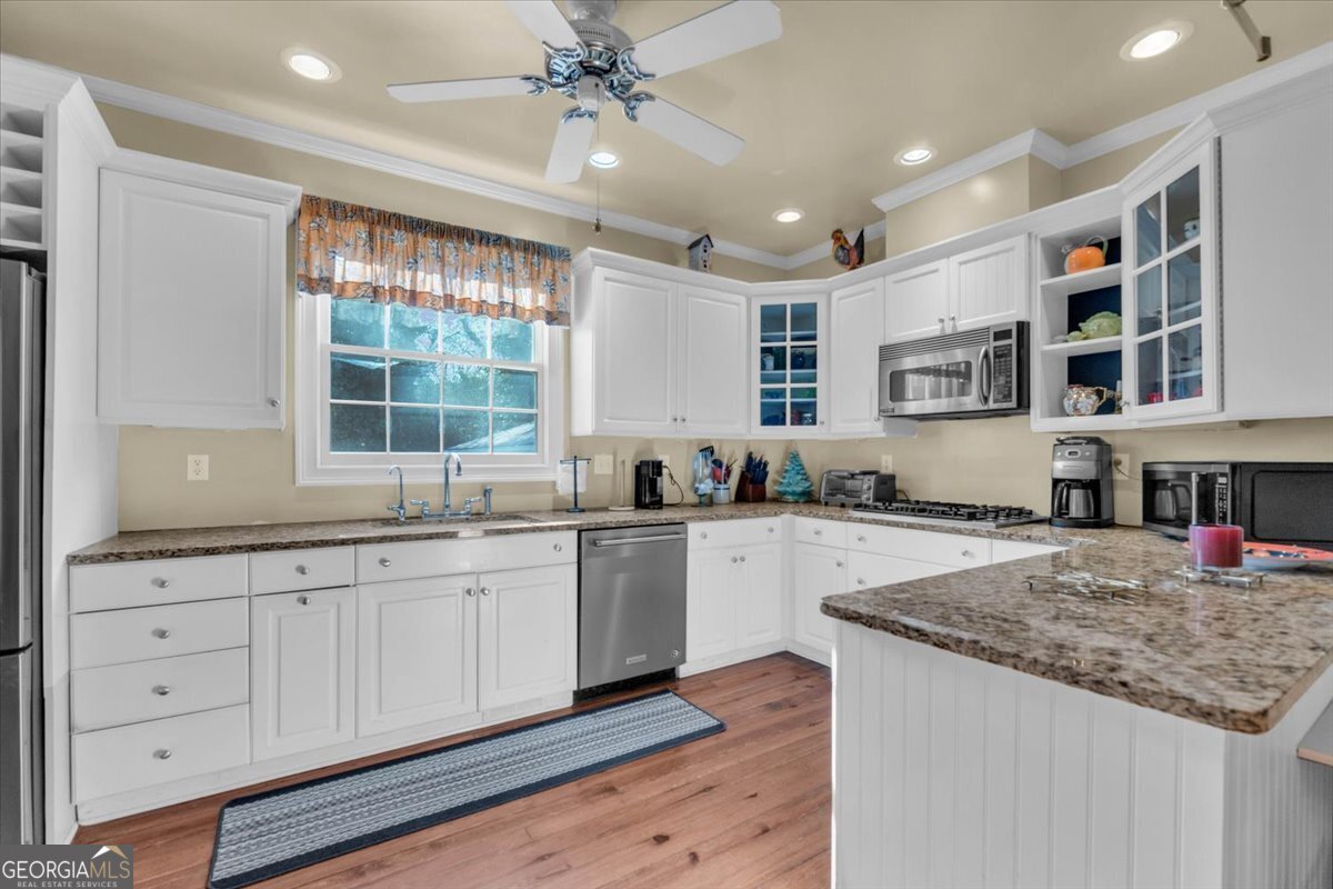 661 East Walton Street Madison, GA 30650 - Photo 11 of 35 a kitchen with stainless steel appliances granite countertop a sink and cabinets