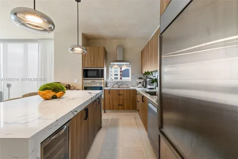 a kitchen with stainless steel appliances granite countertop a sink a stove and a refrigerator