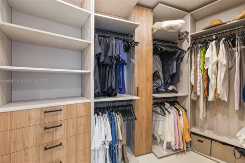 a view of walk in closet with clothes and shoes