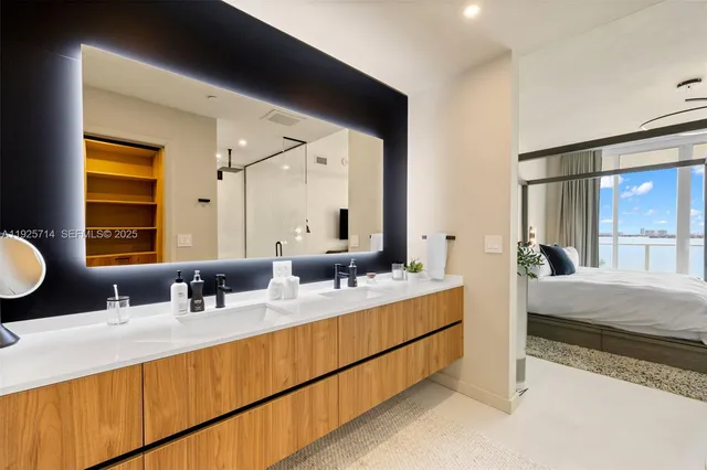 a en suite bathroom with a double vanity sink and a mirror