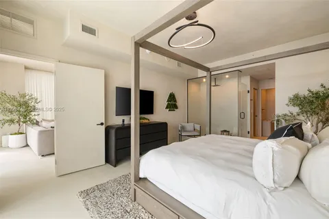 a spacious bedroom with a bed and a chandelier