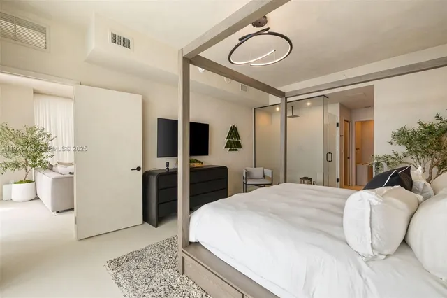 a spacious bedroom with a bed and a chandelier