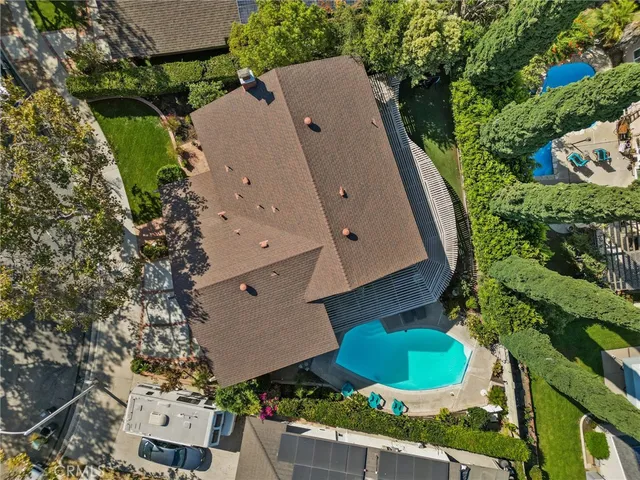 an aerial view of a house with a yard and a large tree