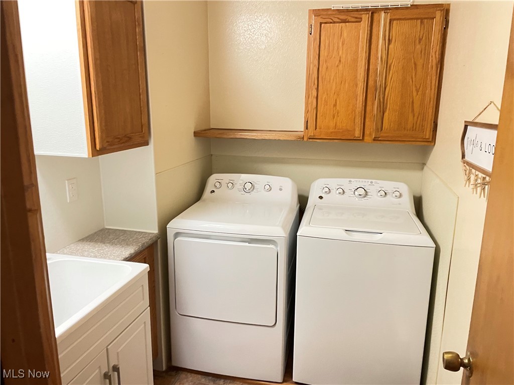 1381 Robb Road Conneaut, OH 44030 - Photo 29 of 50 Laundry area with cabinet space and washing machine and clothes dryer