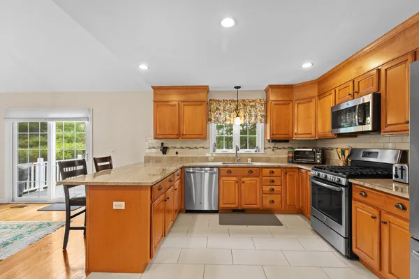 a large kitchen with stainless steel appliances granite countertop a stove sink and cabinets