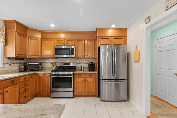 a kitchen with stainless steel appliances granite countertop a refrigerator and a stove top oven
