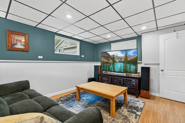 a living room with furniture a flat screen tv and a table