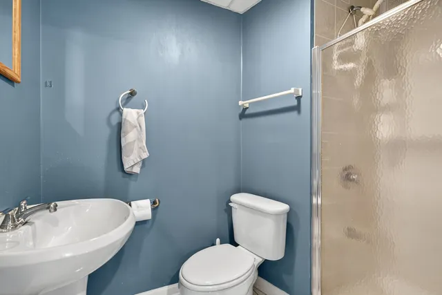 a bathroom with a sink a toilet and shower