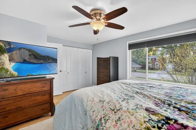 a bedroom with a bed and a large window