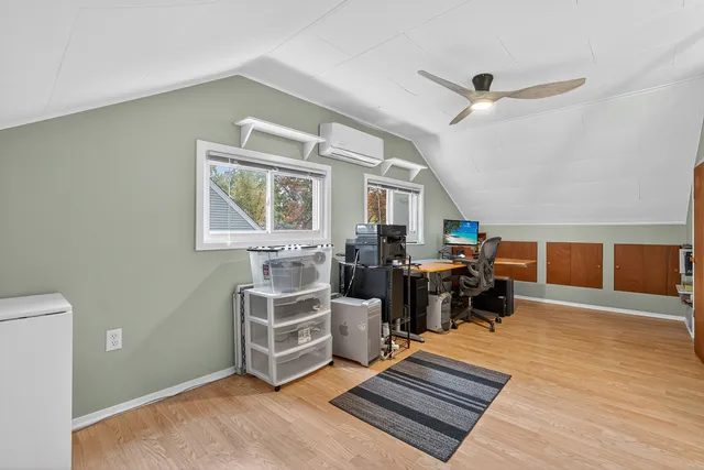 a living room with furniture stove and a wooden floor