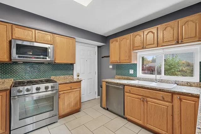 a kitchen with granite countertop cabinets stainless steel appliances and a window