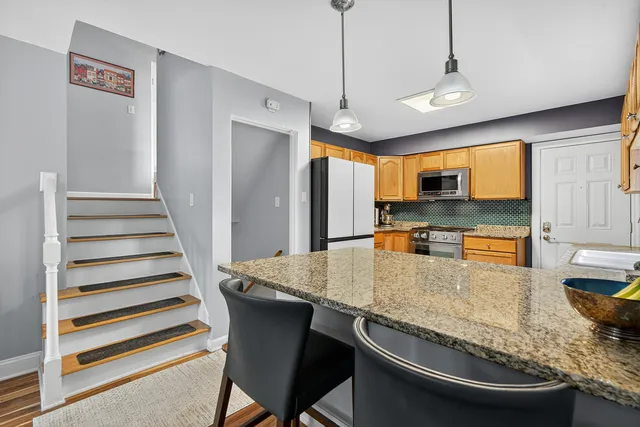 a kitchen with stainless steel appliances granite countertop a sink a stove and refrigerator