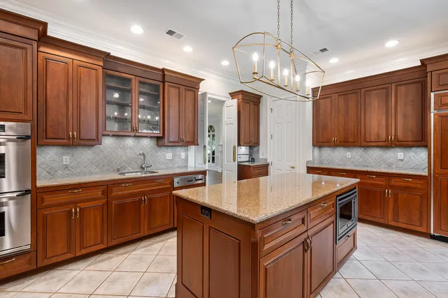a kitchen with stainless steel appliances granite countertop a sink counter space cabinets and a chandelier