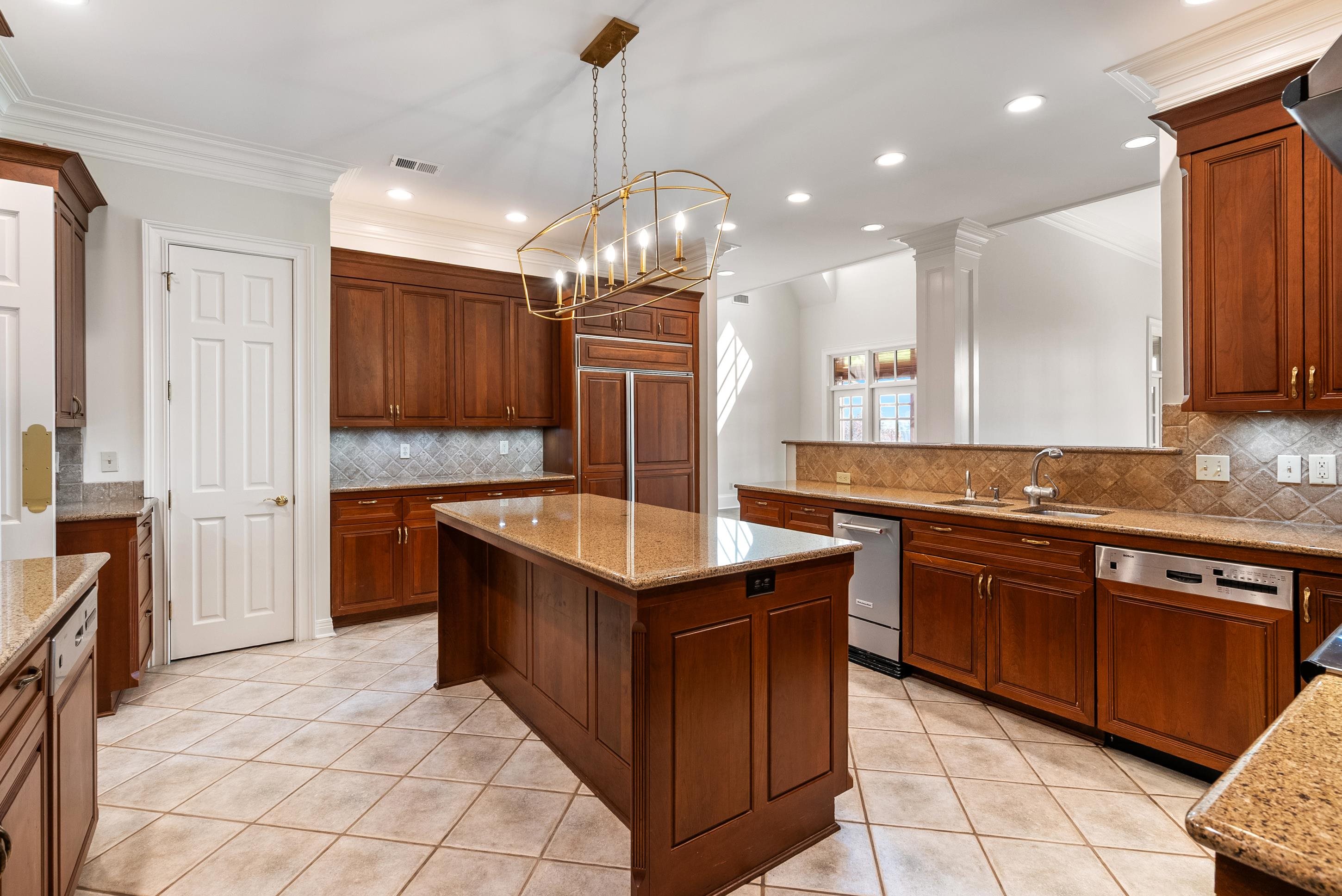 1800 North Collierville Arlington Road Eads, TN 38028 - Photo 13 of 40 a kitchen with stainless steel appliances granite countertop a sink counter space cabinets and a chandelier