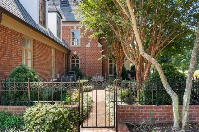 a view of a house with a garden and a wooden fence