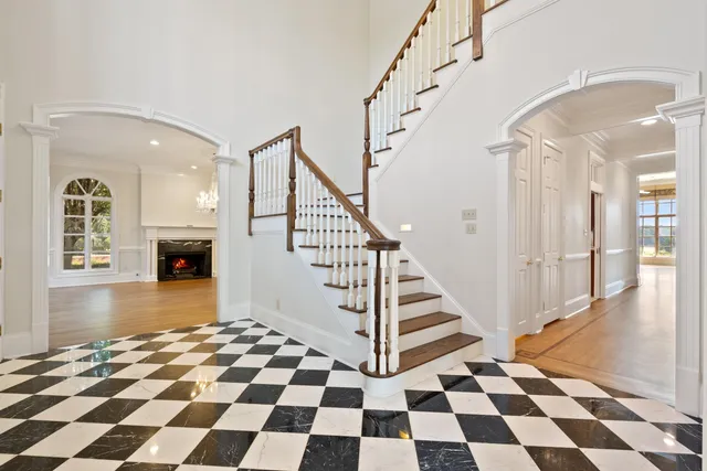 a view of an empty room with wooden floor fireplace and a window