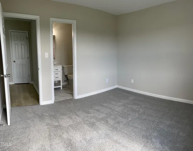 an empty room with closet and wooden door
