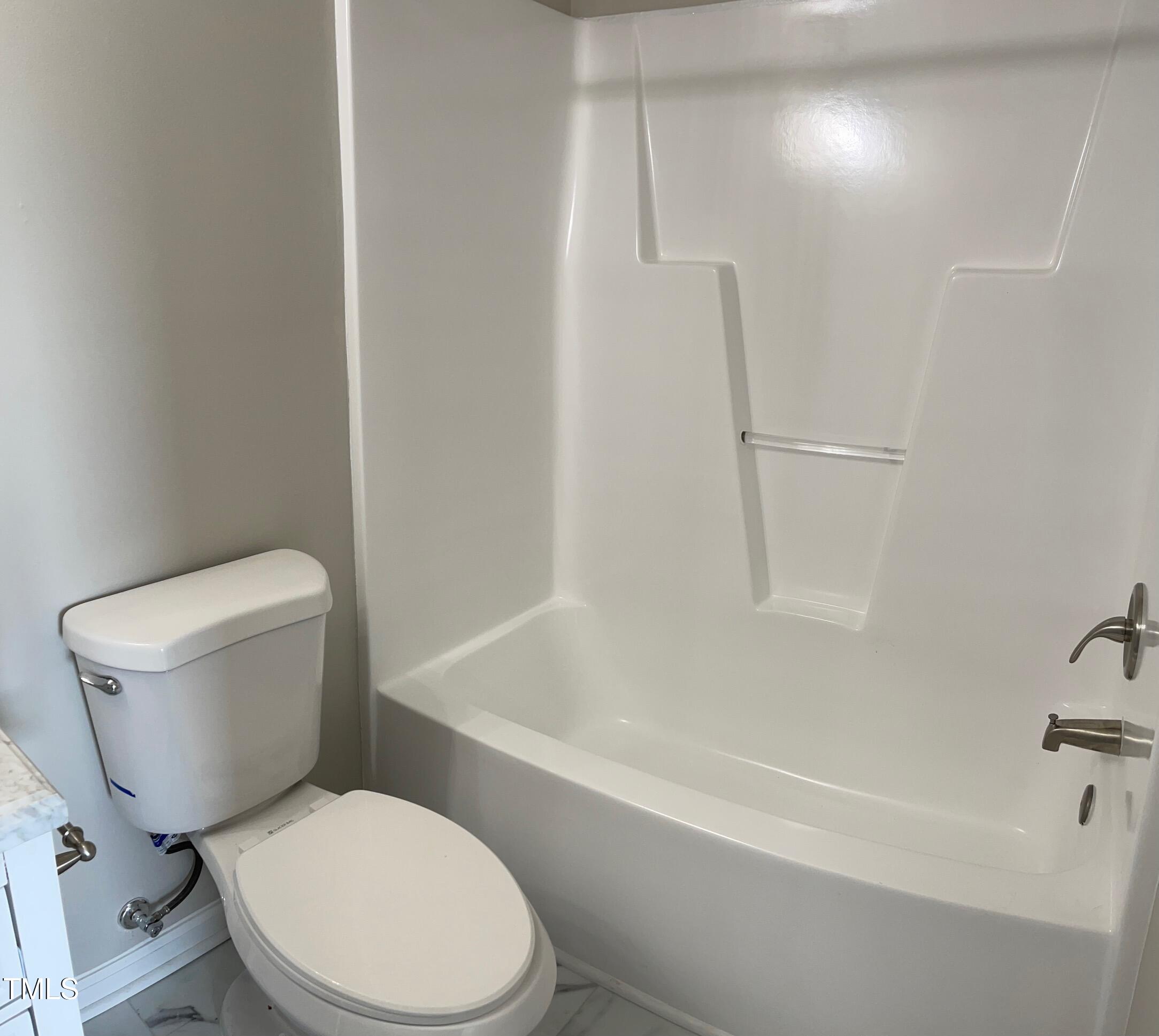 351 East Williams Street Angier, NC 27501 - Photo 16 of 24 a white toilet sitting next to a bath tub