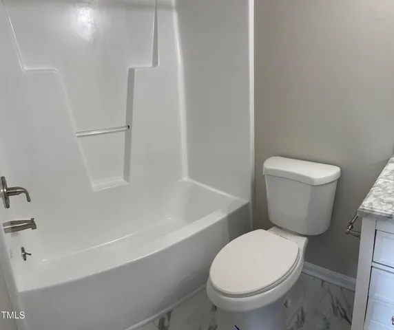 a white toilet sitting next to a bath tub