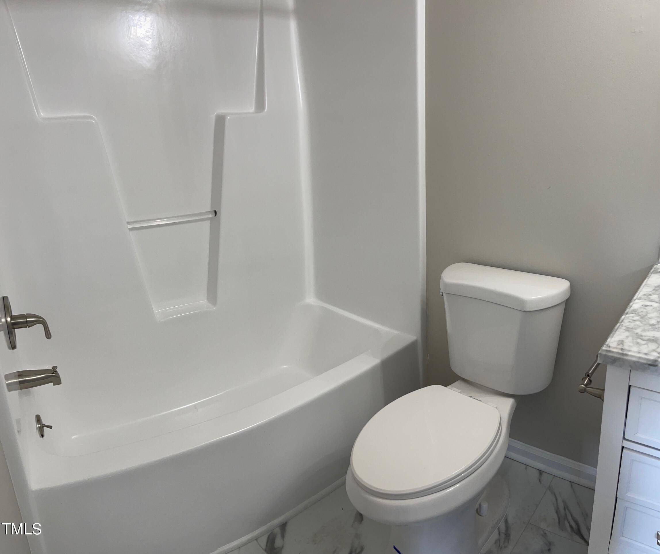 351 East Williams Street Angier, NC 27501 - Photo 21 of 24 a white toilet sitting next to a bath tub