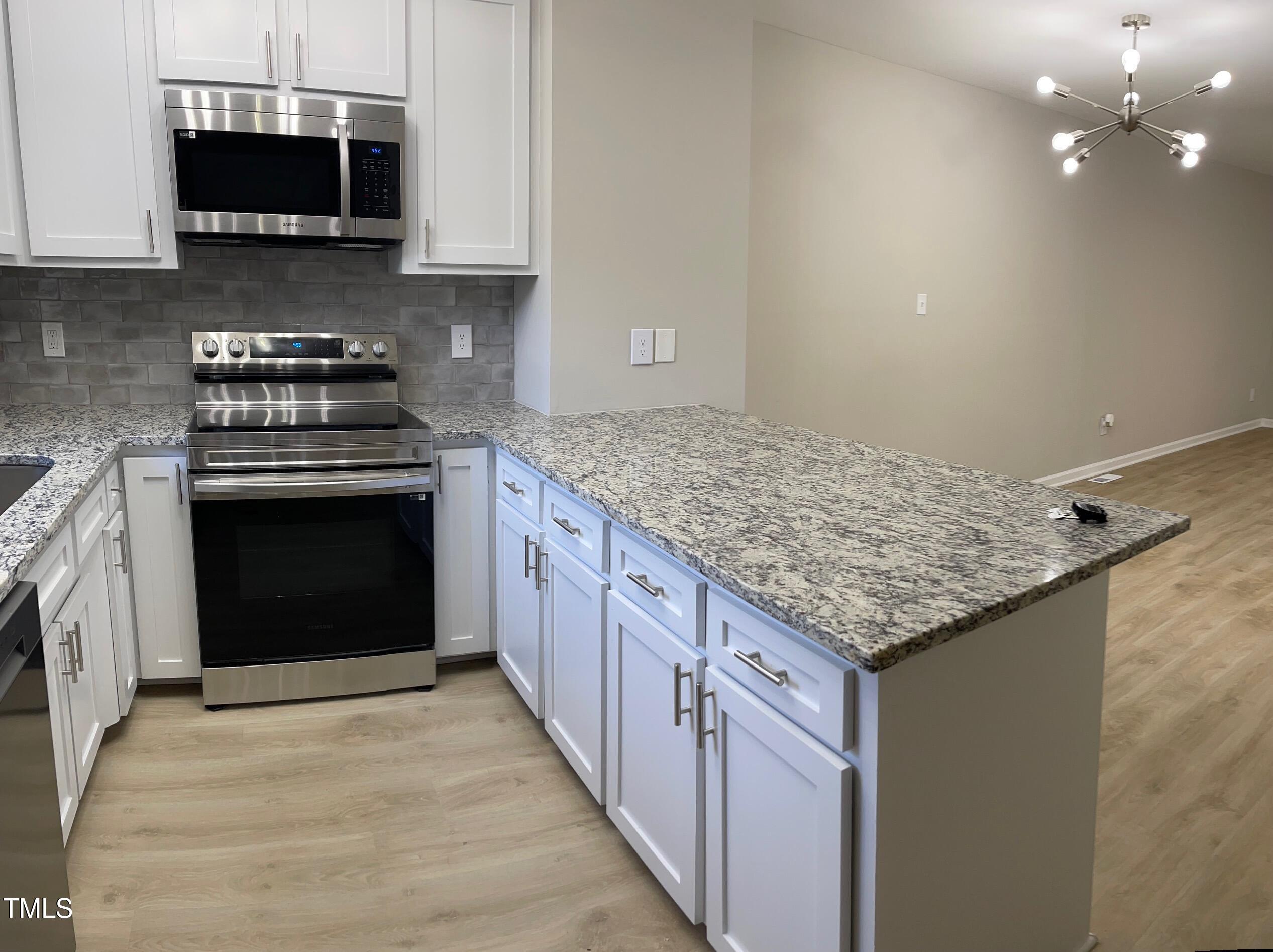 351 East Williams Street Angier, NC 27501 - Photo 4 of 24 a kitchen with stainless steel appliances granite countertop a stove and a wooden cabinets