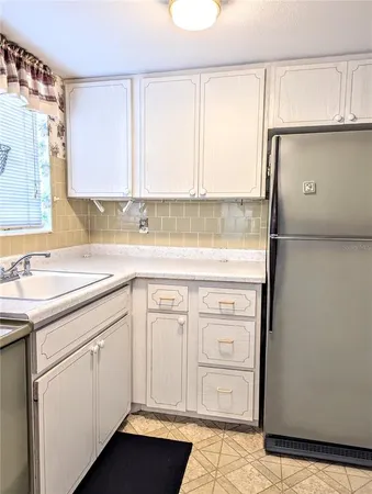 a kitchen with white cabinets and white appliances