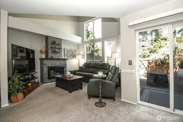 a living room with furniture a fireplace and a flat screen tv