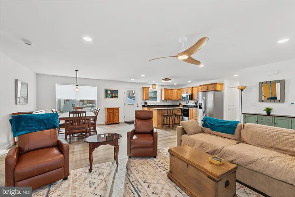 a living room with furniture kitchen view and a chandelier