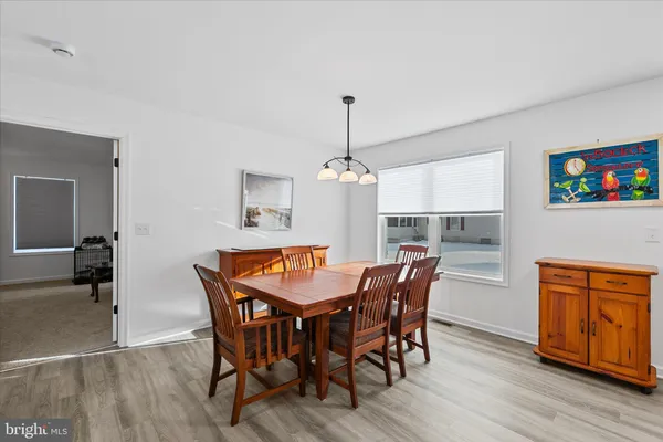 a dining room with furniture wooden floor a rug and a chandelier