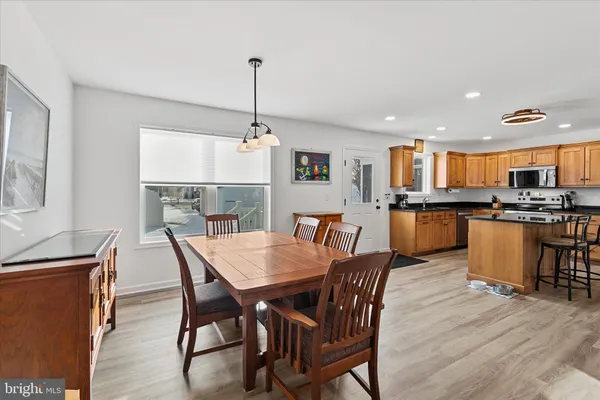 a view of a dining room and livingroom with furniture wooden floor a chandelier