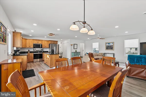 a view of a dining room and livingroom with furniture wooden floor and a chandelier