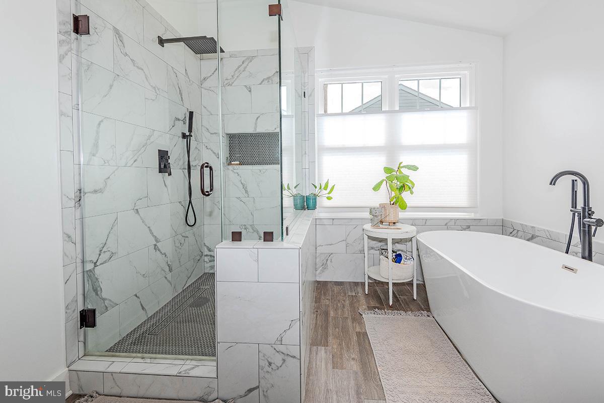 1665 Patrice Circle Crofton, MD 21114 - Photo 26 of 55 a white bath tub sitting next to a white bench sitting next to a white cabinet