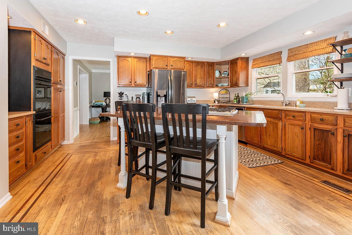 1665 Patrice Circle Crofton, MD 21114 - Photo 9 of 55 a kitchen with stainless steel appliances granite countertop dining table chairs refrigerator and sink