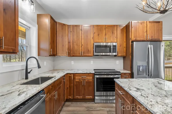 a kitchen with stainless steel appliances granite countertop a stove top oven a sink and dishwasher