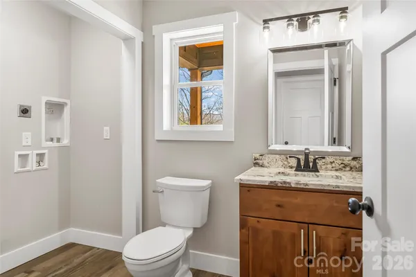 a bathroom with a toilet sink vanity and mirror